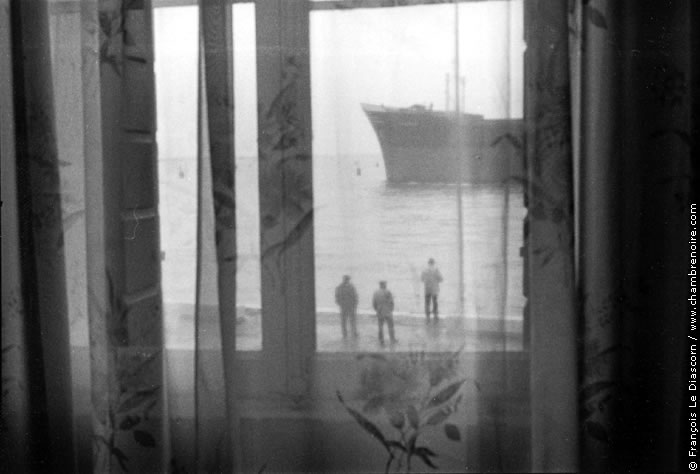 Bateau et trois hommes derrière une fenêtre