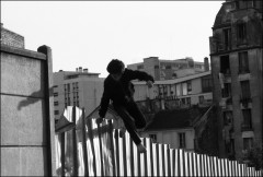 Jeune garçon sautant une palissade