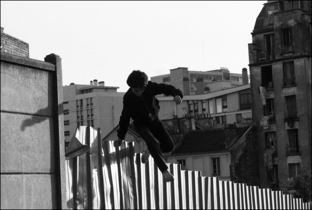 Jeune garçon sautant une palissade