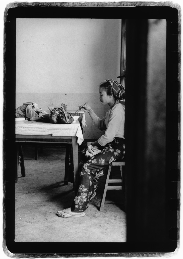 Jeune femme dans une gargote dans un village près de Jinghong dans la province du Xishuangbanna en novembre 1990, Chine