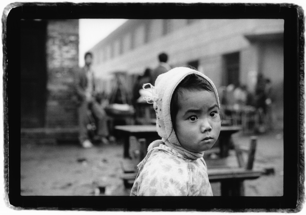 Petite fille près d'une gargote dans les environs de Mohei dans la province du Xishuangbanna en novembre 1990, Chine